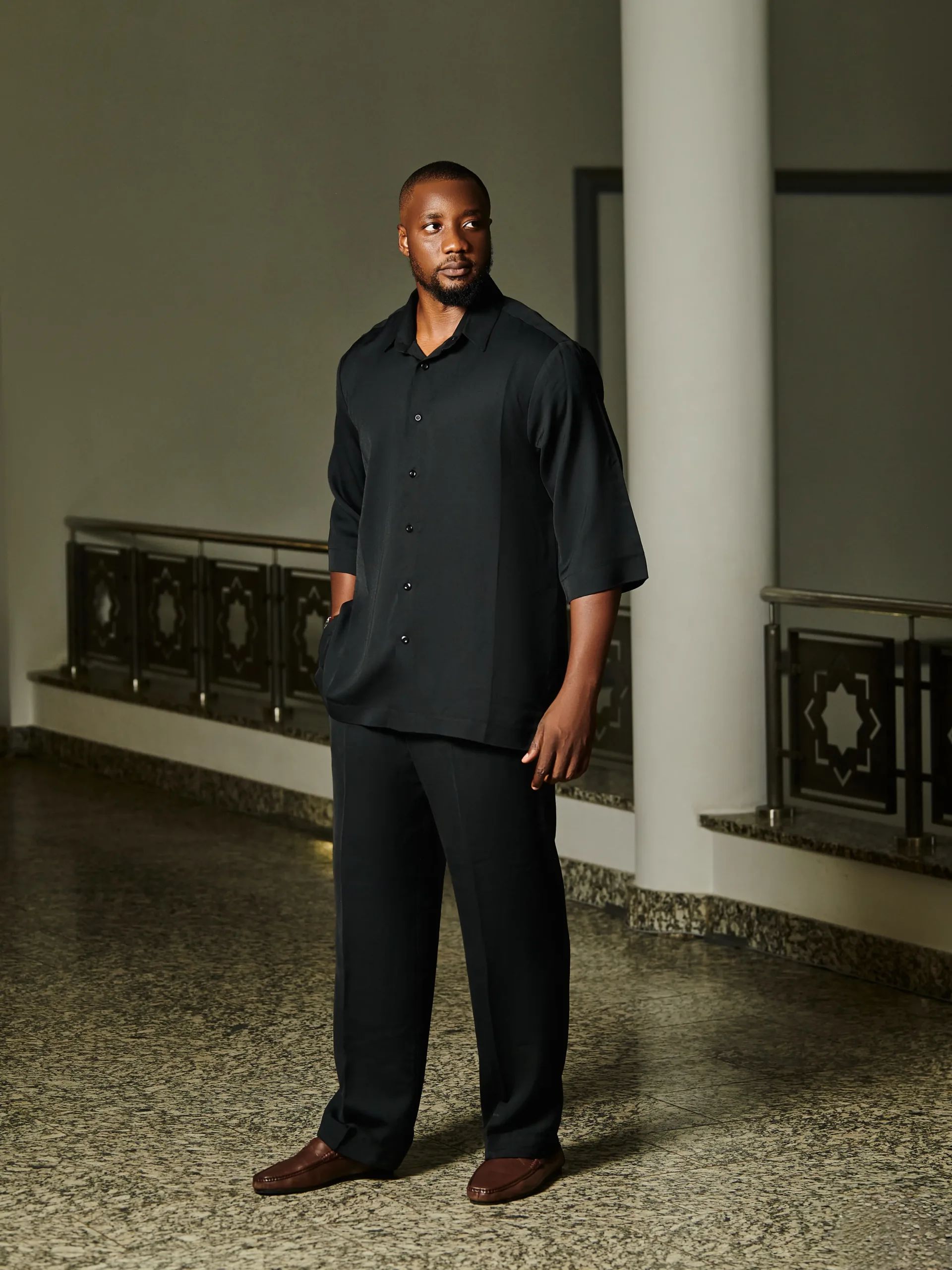 a smooth, black two piece, straight cut trouser and a contemporary half sleeve shirt.